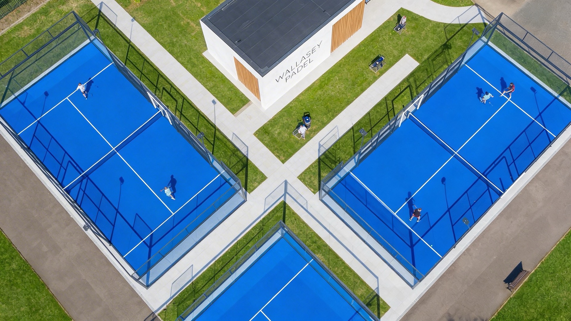 Overhead drone view of three padel courts in a symmetrical layout